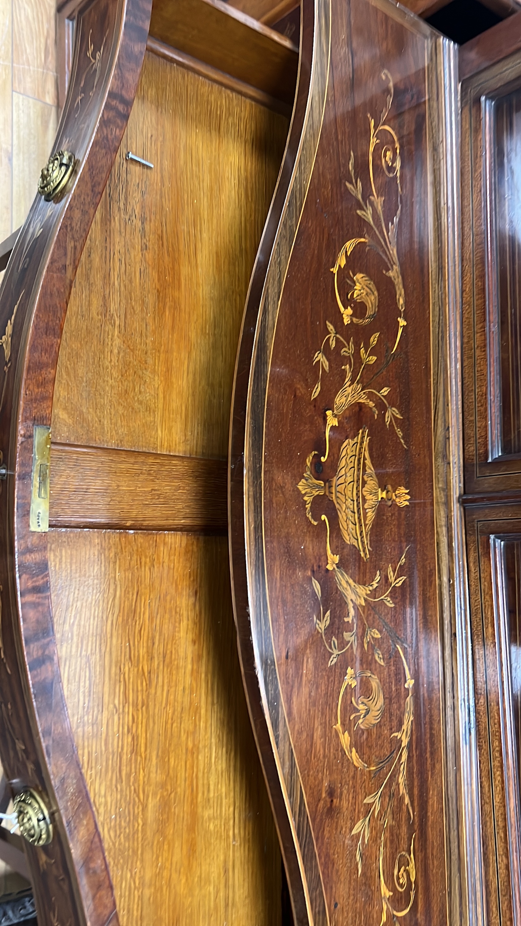 An Edwardian marquetry inlaid mahogany serpentine display cabinet, (bears Edwards & Roberts ivorine plaque), width 92cm, depth 50cm, height 208cm